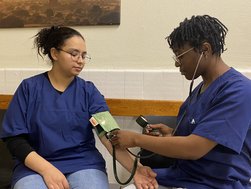 Zwei Auszubildende, die Blutdruckmessen üben
