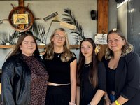 4 junge Frauen stehen in einer Reihe und lachen in die Kamera 