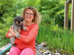 Rehabilitandin Anke Mörl kuschelt mit ihrem Hund Alfie (© AMEOS). 